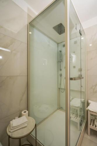a glass shower in a bathroom with a table at infinity Castellabate b & b di Charme in Santa Maria di Castellabate
