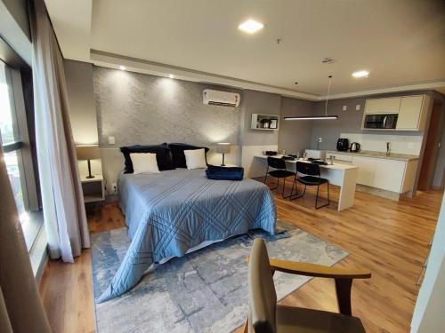 1 Schlafzimmer mit einem großen Bett und einer Küche in der Unterkunft FLAT AFONSO PENA - GESTÃO FGIBRAN in Campo Grande