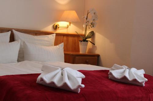 a hotel room with two towels on a bed at Hotel Flora in Fredersdorf