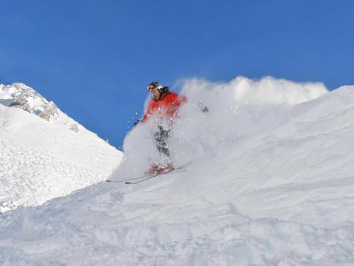 a man is skiing down a snow covered mountain at Haus Adlerkanzel in Scharnitz