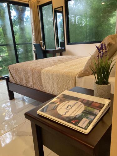 a room with a bed and a table with a book on it at Mountain Top Park Hotel in Quepos