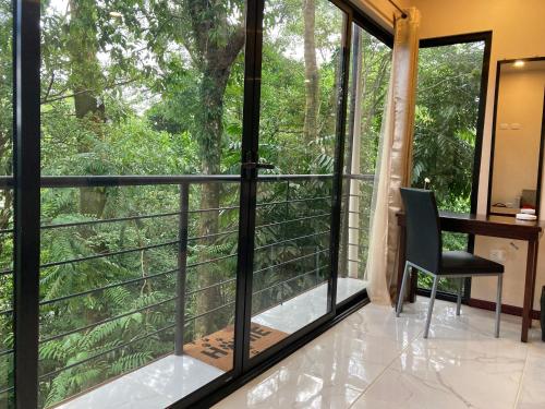 a room with a window and a desk and a chair at Mountain Top Park Hotel in Quepos