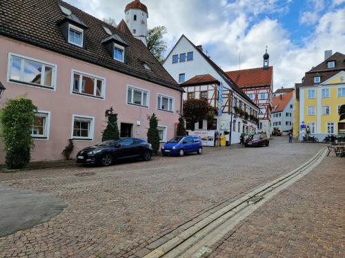 a street in a town with cars parked on the street at Hotel-Restaurant Straussen in Harburg