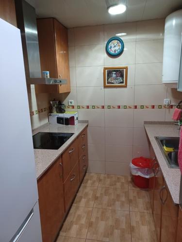 a kitchen with a sink and a clock on the wall at Casa Ferrer Barcelona in Hospitalet de Llobregat