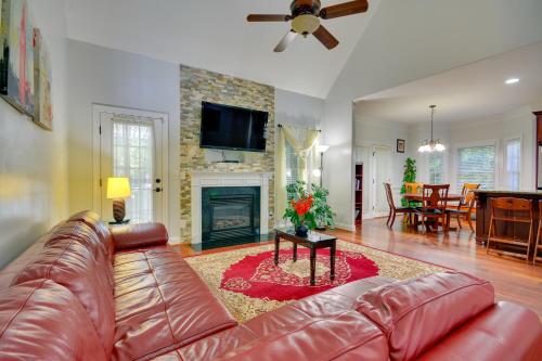 a living room with a leather couch and a fireplace at High Point Vacation Rental with Private Deck! in High Point
