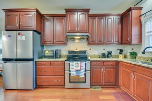 a kitchen with wooden cabinets and stainless steel appliances at High Point Vacation Rental with Private Deck! in High Point