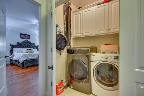 a laundry room with a washer and dryer next to a bed at High Point Vacation Rental with Private Deck! in High Point