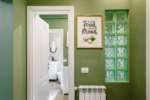 La salle de bains est pourvue d'un mur vert avec une photo sur le mur. dans l'établissement HOLT - Dolce in Napoli, à Bucarest