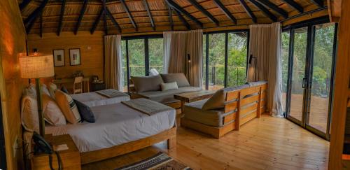 a bedroom with a bed and a couch in a room at Reserva Natural Iguazú - Pristine Luxury Camp in Puerto Libertad