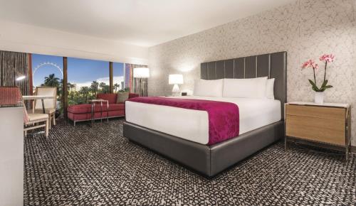 a hotel room with a large bed and a desk at Flamingo Las Vegas Hotel & Casino in Las Vegas