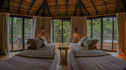 a living room with two couches and a table at Reserva Natural Iguazú - Pristine Luxury Camp in Puerto Libertad