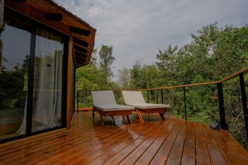a deck with two chairs and a bench on it at Reserva Natural Iguazú - Pristine Luxury Camp in Puerto Libertad