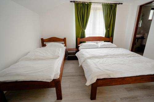 two twin beds in a room with a window at Cabana FloriDeea in Scrind-Frăsinet