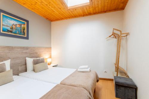 a bedroom with two beds and a skylight at Casa Rústica T2 com Salamandra e Cozinha - Seia - Serra da Estrela - Casa do Loureiro II in Seia