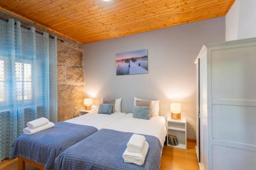 a bedroom with a king sized bed and blue sheets at Casa Rústica T2 com Salamandra e Cozinha - Seia - Serra da Estrela - Casa do Loureiro II in Seia