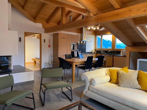 un soggiorno con un divano, un tavolo e una cucina di Attic in the Alps a Luzein