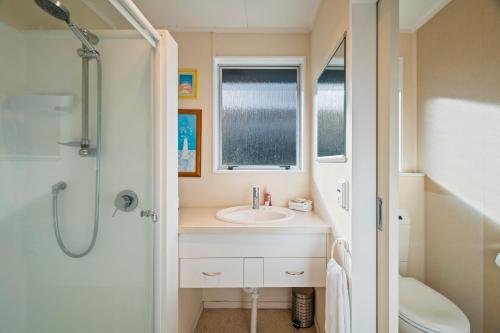 a bathroom with a sink and a shower at Kinder Cottage - Taupo in Taupo