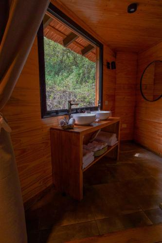a bathroom with two sinks in a room with a window at Reserva Natural Iguazú - Pristine Luxury Camp in Puerto Libertad