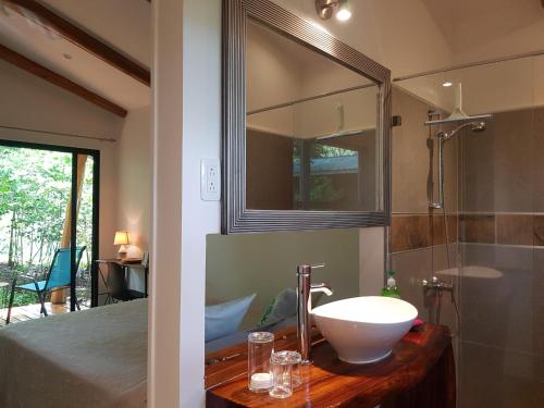 a bathroom with a sink and a mirror at Baliyana Lodge in San José Pinilla