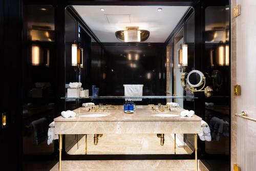 a bathroom with two sinks and a large mirror at Casa Cipriani New York in New York