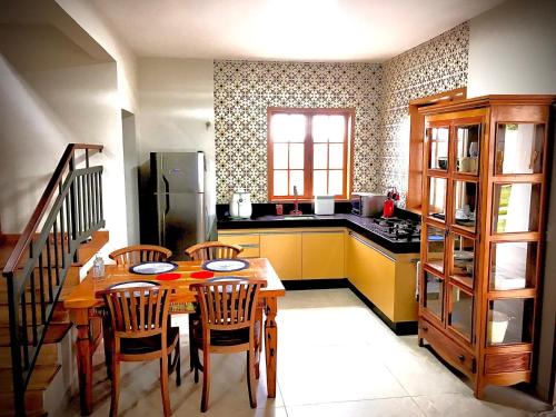 a kitchen with a table and chairs and a refrigerator at Casa 2 Chalé Alto dos Bandeirantes-Tiradentes in Tiradentes