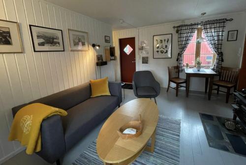 a living room with a couch and a table at Charming Rorbu Stamsund Lofoten in Stamsund