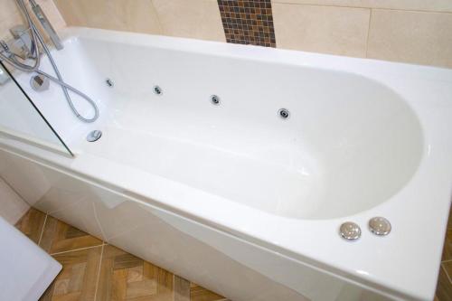 a white bath tub in a bathroom at 4 bedroom property in Birmingham in Birmingham