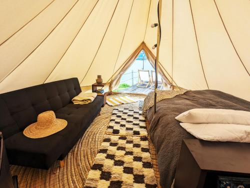 ein Zelt mit einer Couch mit Hut drauf in der Unterkunft Glamping Yerbabuena in Toca