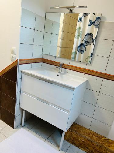 a bathroom with a white sink and a mirror at Chambre d’hotes in Démouville