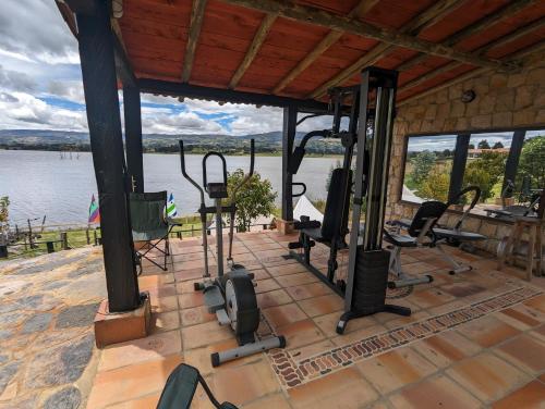 einen Fitnessraum mit Trainingsgeräten auf einer Terrasse neben dem Wasser in der Unterkunft Glamping Yerbabuena in Toca