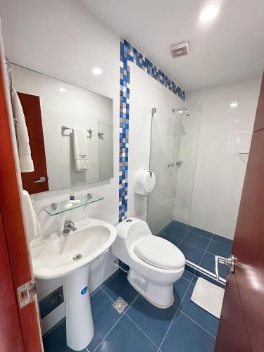 a bathroom with a white toilet and a sink at Hotel AguaMarina Rodadero Santa Marta in Gaira
