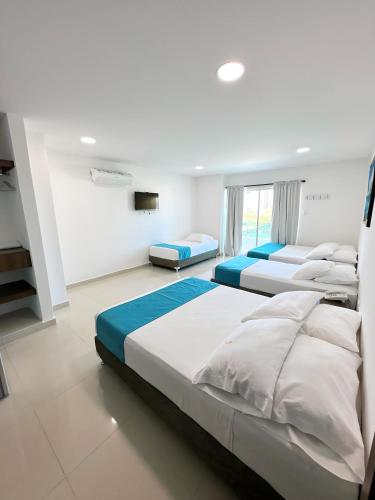 a large bedroom with four beds in it at Hotel AguaMarina Rodadero Santa Marta in Gaira