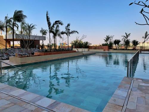a swimming pool with blue water in a resort at Hot Beach Suites Olimpia Resort in Olímpia