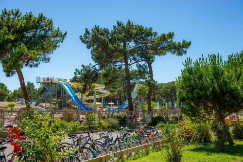 - un groupe de vélos garés en face d'un parc aquatique dans l'établissement Mobil-Home Camping Club 5* Montalivet, à Vendays-Montalivet