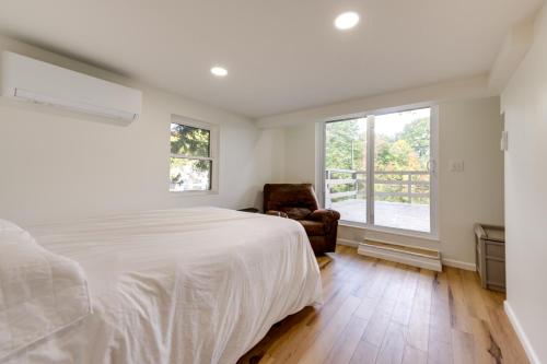a bedroom with a bed and a chair and a window at Horseshoe Lake Vacation Rental with Deck and Kayaks! in Batavia
