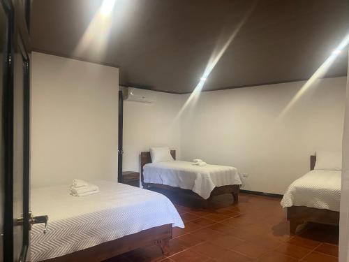 a room with two beds and lights on the wall at Hotel y Restaurante El Páramo in San Rafael Norte