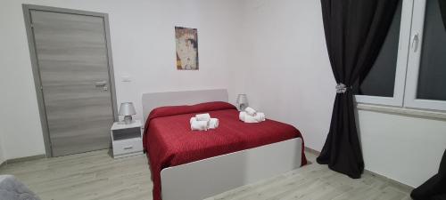 ein Schlafzimmer mit einem roten Bett mit zwei Handtüchern darauf in der Unterkunft Residence Volpe in Caronia Marina