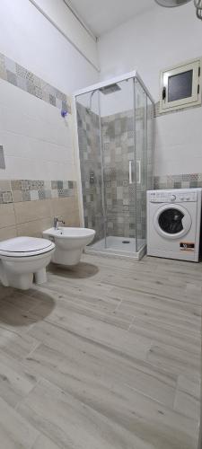 ein Badezimmer mit einem WC, einem Waschbecken und einer Waschmaschine in der Unterkunft Residence Volpe in Caronia Marina
