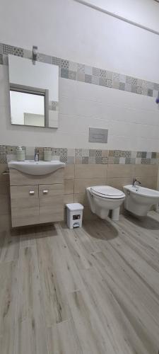 ein Badezimmer mit zwei Waschbecken, einem WC und einem Spiegel in der Unterkunft Residence Volpe in Caronia Marina