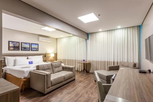 a hotel room with a bed and a table and chairs at Blue Tree Premium Florianópolis in Florianópolis