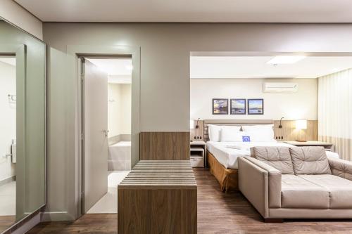 a hotel room with a bed and a couch at Blue Tree Premium Florianópolis in Florianópolis