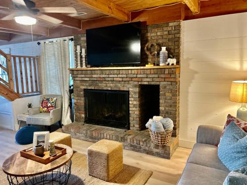 a living room with a fireplace with a flat screen tv at Best Life Now Cottage in Crane Hill