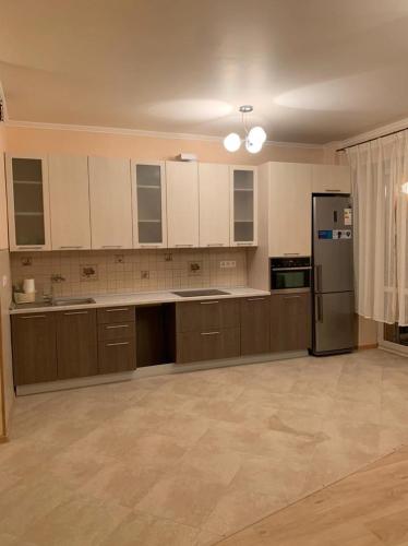 a large kitchen with white cabinets and a refrigerator at Graz Narek house 6 in Altenfelden