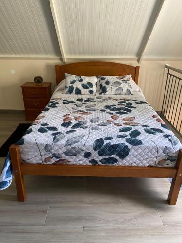 ein Bett mit einer Decke in einem Schlafzimmer in der Unterkunft casa caminho da praia in Porto da Cruz