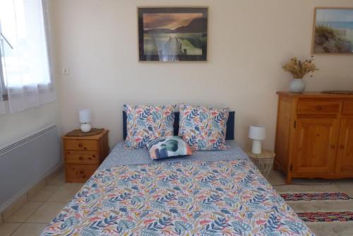 um quarto com uma cama com um cobertor azul e almofadas em Studio em Pornic