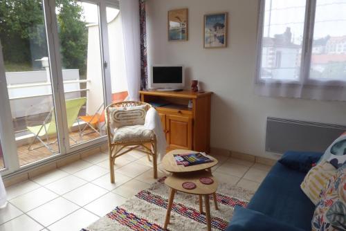 a living room with a blue couch and a tv at Studio in Pornic