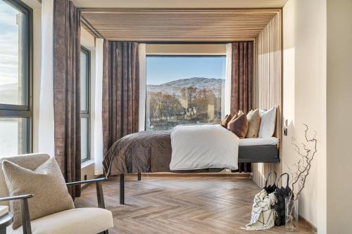 a bedroom with a bed and a large window at Steam Pier Adventure Hotel in Kvaløya