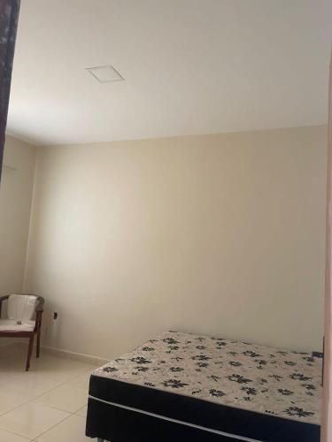 a white room with a bed and a chair at Casa de buzios in Búzios