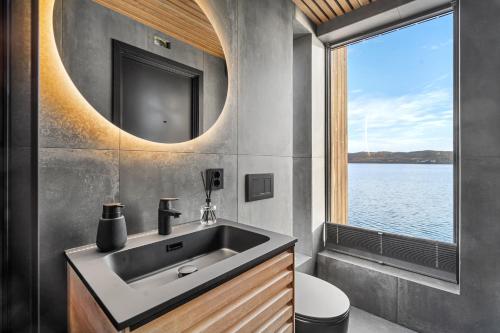 a bathroom with a sink and a mirror and a window at Steam Pier Adventure Hotel in Kvaløya