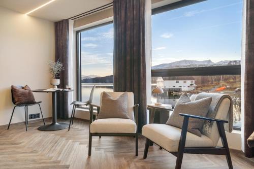 a living room with chairs and a large window at Steam Pier Adventure Hotel in Kvaløya